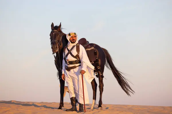 Hombre Con Ropa Tradicional Arabia Saudita Desierto Con Semental Negro Imagen De Stock