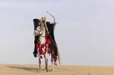 Saudi man in traditional clothing with his white stallion clipart