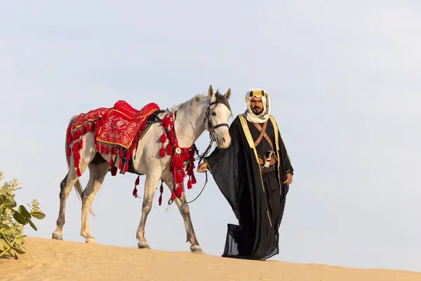Саудовский Мужчина Традиционной Одежде Своим Белым Жеребцом Лицензионные Стоковые Изображения