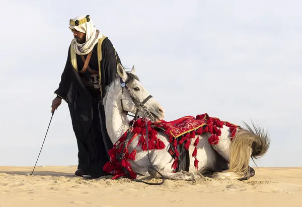 Саудовский Мужчина Традиционной Одежде Своим Белым Жеребцом Стоковое Изображение