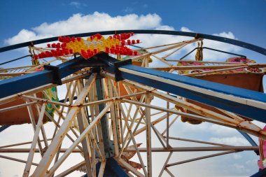 Mavi gökyüzüne karşı eski, paslı, paslı bir dönme dolaba yaklaş. Terk edilmiş dönme dolabın ayrıntılı görüntüsü.