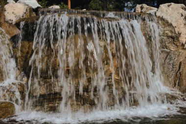 Aşağıdaki gölete düşen bir su birikintisi çok fazla su püskürtüsü, kabarcık ve su sıçratır.