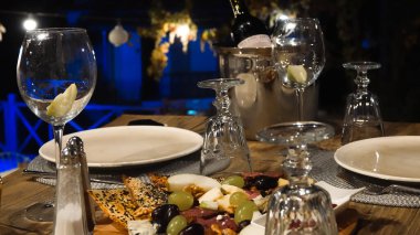 Şarap aperatifleri masada şarap şişesi, tabak ve şarap bardakları için hazırlandı. Hoş bir gece atıştırması. Lezzet Tabağı.