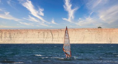 Profesyonel Uçurtma Sörfçüsü denizdeki dalgalar üzerinde hareket halinde. Uçurtma dalgalarda slalom yapıyor. Imbros Adası, Gökçeada, Türkiye