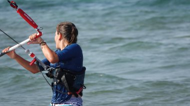 Profesyonel kadın uçurtma sörfçüsü denizdeki dalgalarda hareket halinde. Uçurtma dalgalarda slalom yapıyor. Imbros Adası. Gökçeada, Çanakkale Türkiye 08.20.2022