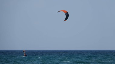 Profesyonel Uçurtma Sörfçüsü denizdeki dalgalar üzerinde hareket halinde. Uçurtma dalgalarda slalom yapıyor. Imbros Adası. Gökçeada, Çanakkale Türkiye 08.20.2022