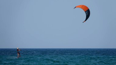 Profesyonel Uçurtma Sörfçüsü denizdeki dalgalar üzerinde hareket halinde. Uçurtma dalgalarda slalom yapıyor. Imbros Adası. Gökçeada, Çanakkale Türkiye 08.20.2022