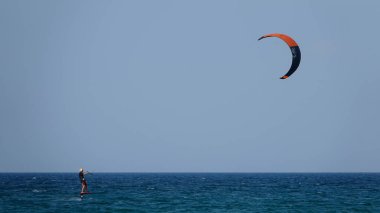 Profesyonel Uçurtma Sörfçüsü denizdeki dalgalar üzerinde hareket halinde. Uçurtma dalgalarda slalom yapıyor. Imbros Adası. Gökçeada, Çanakkale Türkiye 08.20.2022