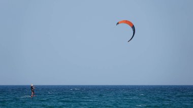 Profesyonel Uçurtma Sörfçüsü denizdeki dalgalar üzerinde hareket halinde. Uçurtma dalgalarda slalom yapıyor. Imbros Adası. Gökçeada, Çanakkale Türkiye 08.20.2022
