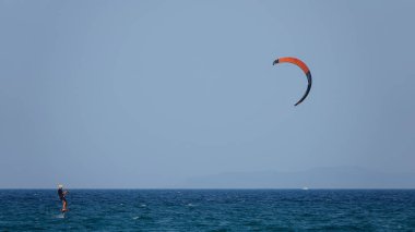 Profesyonel Uçurtma Sörfçüsü denizdeki dalgalar üzerinde hareket halinde. Uçurtma dalgalarda slalom yapıyor. Imbros Adası. Gökçeada, Çanakkale Türkiye 08.20.2022