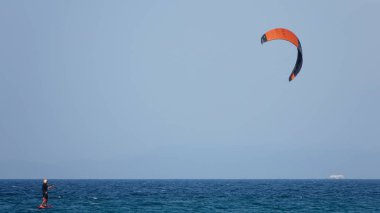Profesyonel Uçurtma Sörfçüsü denizdeki dalgalar üzerinde hareket halinde. Uçurtma dalgalarda slalom yapıyor. Imbros Adası. Gökçeada, Çanakkale Türkiye 08.20.2022