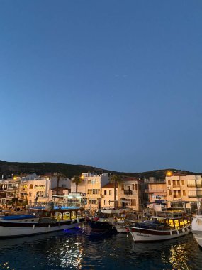 Kıyı şeridi gece görüşü, Foca, İzmir, Türkiye 'deki deniz manzaralı ev ve gemiler. 07.06.2022