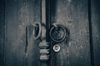 Old rusty lock hook and modern door lock on wooden door. Door of old rustic wood with padlock vintage concept.