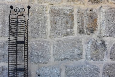 Vintage Rustic Wrought Iron CD disc Storage stand in front of a old stone wall
