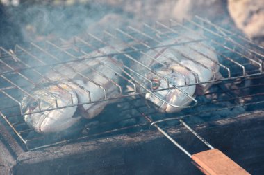 Close up view of fresh sea breams fish on grill. 