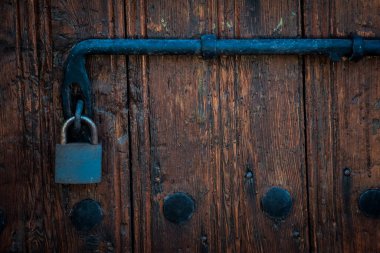 Old rusty lock hook and padlock on wooden door. Old rustic wooden door with padlock vintage concept