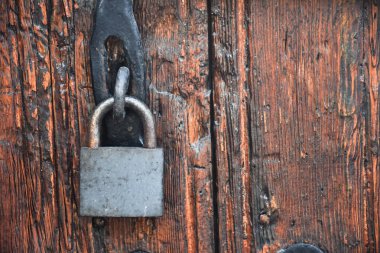 Old rusty lock hook and padlock on wooden door. Old rustic wooden door with padlock vintage concept