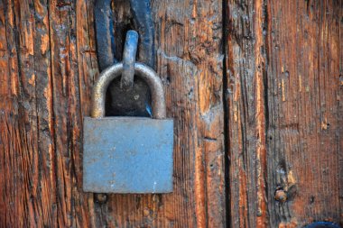 Old rusty lock hook and padlock on wooden door. Old rustic wooden door with padlock vintage concept