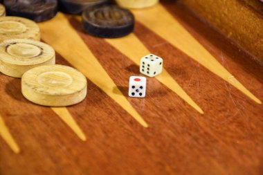 Two dice rolled on a backgammon game board. Backgammon game black versus white with dice. Backgammon set with rolling dice