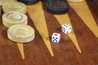Two dice rolled on a backgammon game board. Backgammon game black versus white with dice. Backgammon set with rolling dice
