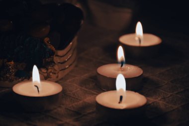 Candles with objects such as romantic candles, chestnuts, sailing ship on a dim floor for winter emotional wallpaper, backgrounds. Can be used for spa and meditation