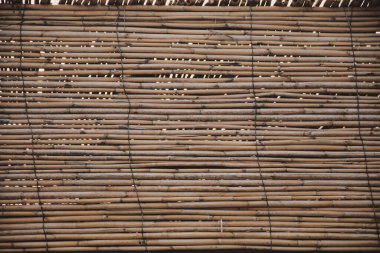 Wall made of steel wire and bamboo branches. Bamboo background detail