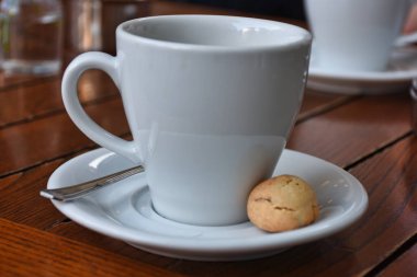  a cup of espresso  coffee served with a cookie on wooden table. Vintage, romantic coffee concept