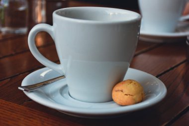  a cup of espresso  coffee served with a cookie on wooden table. Vintage, romantic coffee concept