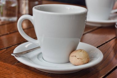  a cup of espresso  coffee served with a cookie on wooden table. Vintage, romantic coffee concept