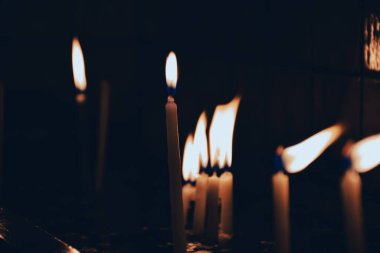 Candles burning in front of the dim tiled wall in the  church. For christmas wishes and pray background