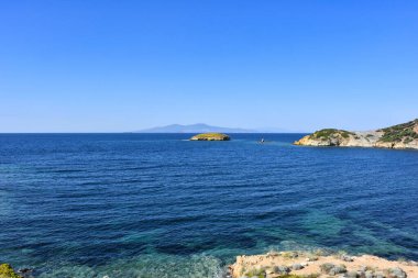 A Small islet, cliffs, mountain and bay view in the virgin bays of izmir Foca. Virgin coves of the Aegean Sea. Phokaia, Izmir Bays.The view of the Karaburun mountains and the Aegean Gulf from Foa.