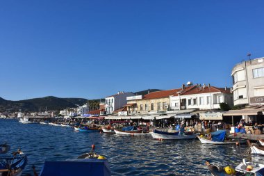 Izmir, Foca Turkey. 07.06.2021 Streets leading to the sea, fishing boats, restaurants, and nomadic people walking in Old Foa. Foca is a famous town on the Aegean coast