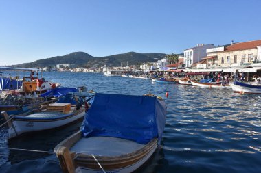 Izmir, Foca Turkey. 07.06.2021 Streets leading to the sea, fishing boats, restaurants, and nomadic people walking in Old Foa. Foca is a famous town on the Aegean coast