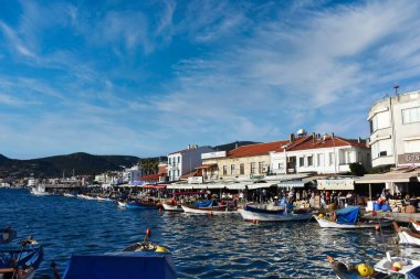 İzmir, Foca Turkey. 07.06.2021 Deniz, balıkçı tekneleri, restoranlar ve Old Foa 'da yürüyen göçebe insanlar. Foca, Ege kıyısında ünlü bir şehirdir.