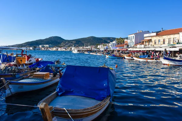 Foca, Izmir, Turkey 29 Jun 2021 Fishing boats with Turkish flags along the coastline of Foca holiday resort, cafe, hotels and restaurants on the opposite shore. Aegean town of Izmir.