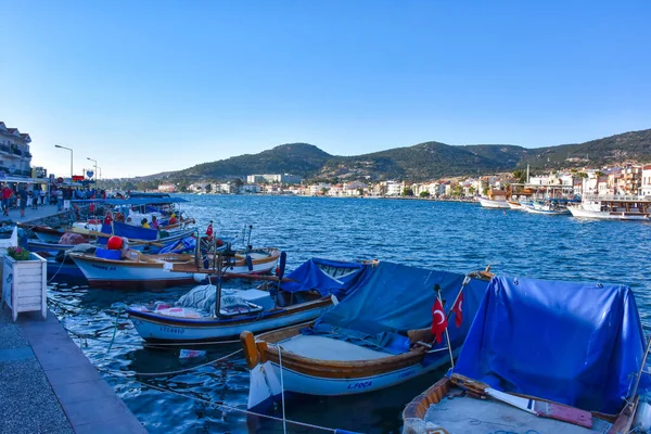 Foca, Izmir, Turkey 29 Jun 2021 Fishing boats with Turkish flags along the coastline of Foca holiday resort, cafe, hotels and restaurants on the opposite shore. Aegean town of Izmir.