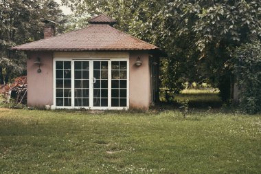 Outside view of a garden cottage in autumn. View of Small outbuilding in a garden. vintage autumn cards, wallpaper