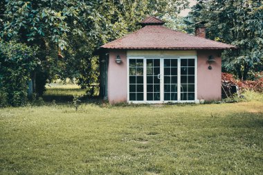 Outside view of a garden cottage in autumn. View of Small outbuilding in a garden.