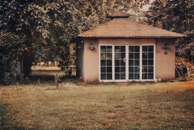 Outside view of a garden cottage in autumn. View of Small outbuilding in a garden. vintage autumn cards, wallpaper