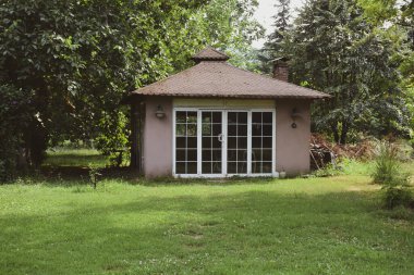 Outside view of a garden cottage in spring. View of Small outbuilding in a garden.