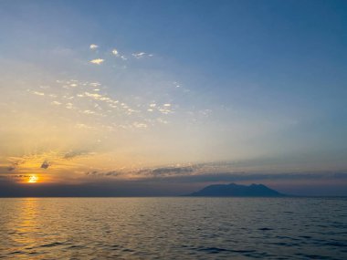 Günbatımında Kalekoy Limanı 'ndan Anakkale, Gökceada' daki Semendirek Adası 'na uzak görüş