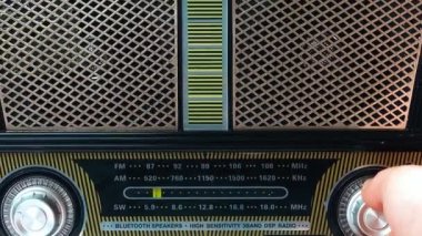 Eski Bağbozumu Analog Alıcısı 'nda Frekansı Ayarlayan Kadın Parmaklar. Kısa dalgalı taşınabilir FM radyo, 80 'li, 90' lı yılların çalgıcısı panelinde bir müzik radyosu ara.