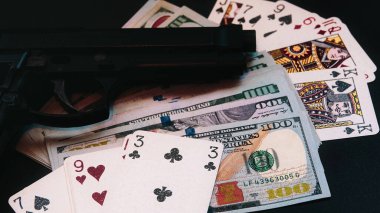 Silah, iskambil kâğıdı, masada yatan para. Suç sorunları. Yasadışı satış. Sosyal yozlaşma. sinematografik konsept