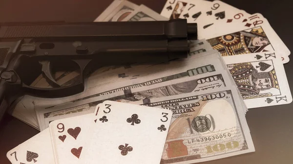 Gun, playing cards, money lying on the table. Criminal problems. Illegal selling.social corruption. cinematographic concept