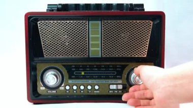 Eski Bağbozumu Analog Alıcısı 'nda Frekansı Ayarlayan Kadın Parmaklar. Kısa dalga taşınabilir FM radyo panelinde çevirmeli bir radyo istasyonu ara.