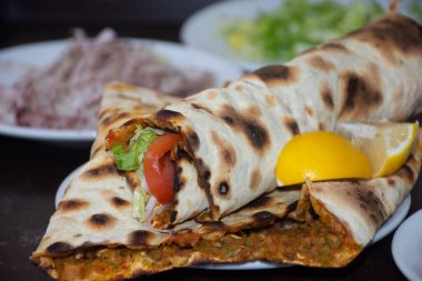  Lahmacun, bir Türk pizzası, soğan, domates ve salatayla süslenir..