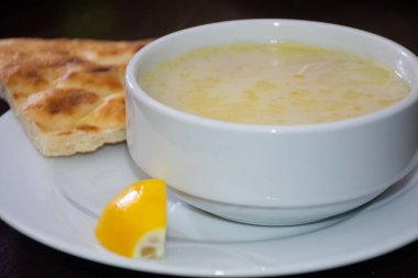  Geleneksel tavuk çorbası bir dilim limon ve pide ekmeğiyle servis edilir. Manzarayı kapat. Ramazan başlangıç menüsü