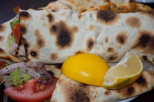  Lahmacun, bir Türk pizzası, soğan, domates ve salatayla süslenir..