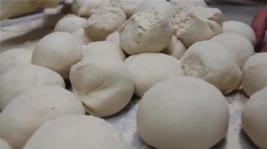 Pasta mutfağında erkek ellerini kapatarak pizza ya da pide hamuru yapan Şef, Türk lahmacunu hazırlıyor.