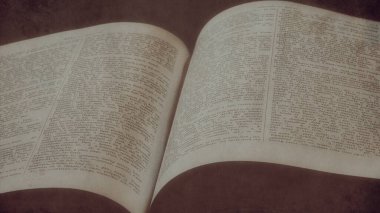 An ancient Greek Latin dictionary with soft yellow light on a tumbled black background, Education, religion, spiritual, knowledge concept. 